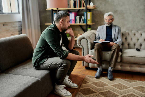 istock Depressed young caucasian man talking with psychotherapist 1304597398
