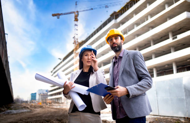 istock Multi-ethnic engineer workers with blueprint on the construction site stock photo 1304597491