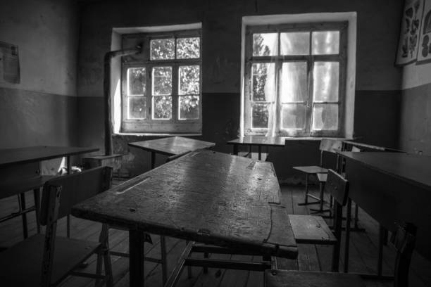 istock Old and abandoned school classroom interior, in black and white. 1304597752