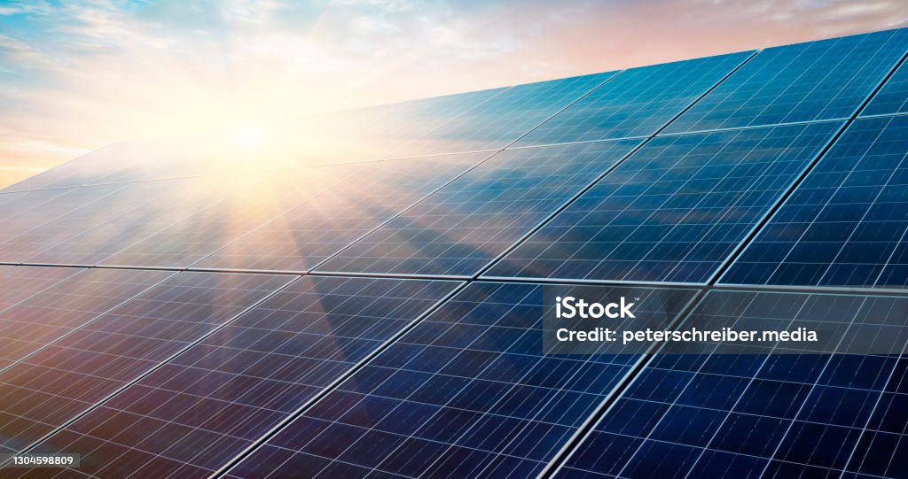 Photovoltaic solar panel system Photovoltaic system in front of a bright sunrise morning sky Solar Panel Stock Photo