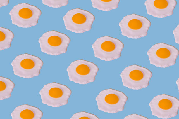 istock Food pattern of fried eggs on bright blue background 1304600943