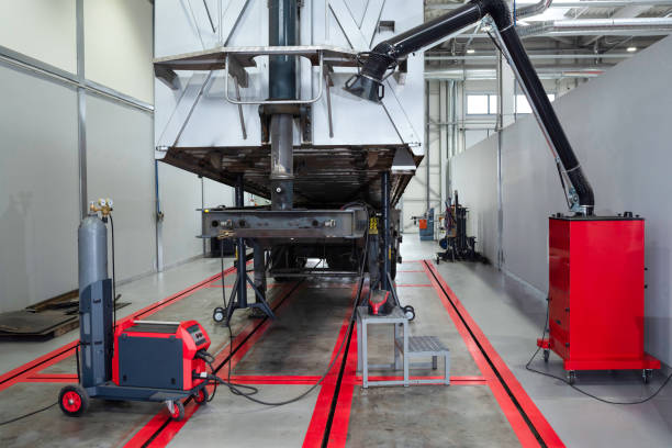 istock Servicing and repairing trucks in a large garage. Cargo trailer undergoing technical inspection at a car service. Car service, diagnostics 1304601902