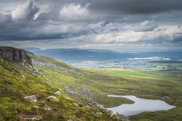 istock Green fields and large boulders illuminated by sunlight in Cuilcagh Mountain Park 1304606223
