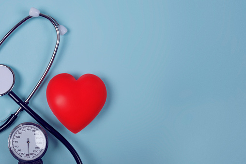 Top view of heart and stethoscope on blue background