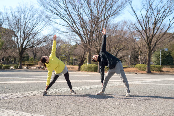 пара осуществляет вместе в парке - yoga winter urban scene outdoors стоковые фото и изображения