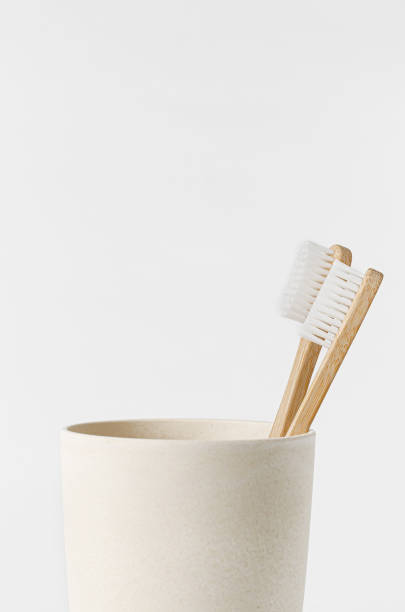 istock Bamboo toothbrushes in eco cup on white background. Copy space, close up. Ecological materials concept. 1304608671