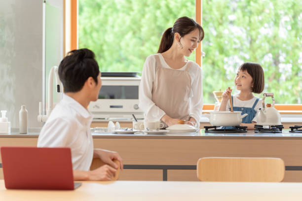 junge japanische familie entspannen in der küche - two parent family indoors home interior domestic kitchen stock-fotos und bilder