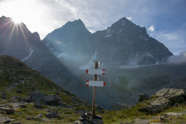 istock Trail marker with sun rising over distant mountains 1304611970