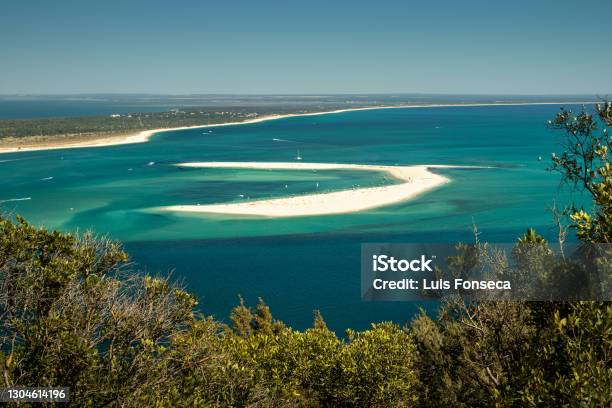 Sand Bank In Front Of Tróia Beach In Portugal Surrounded By Turquoise Waters With Moored Pleasure Boats And In The Background The Beach Line Of The Tróia Peninsula On A Summer Day Stock Photo - Download Image Now