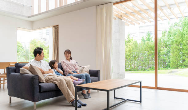 ソファでリラックスした若い日本人家族 - 家 ストックフォトと画像