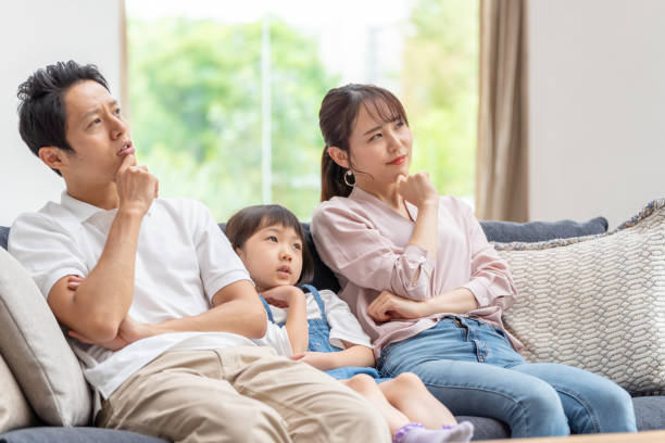 istock young japanese family thinking on the sofa 1304614951