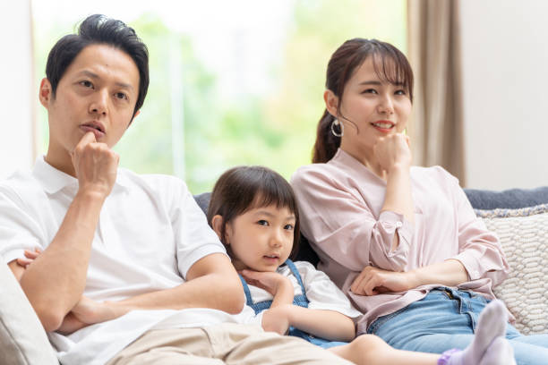 istock young japanese family thinking on the sofa 1304614953