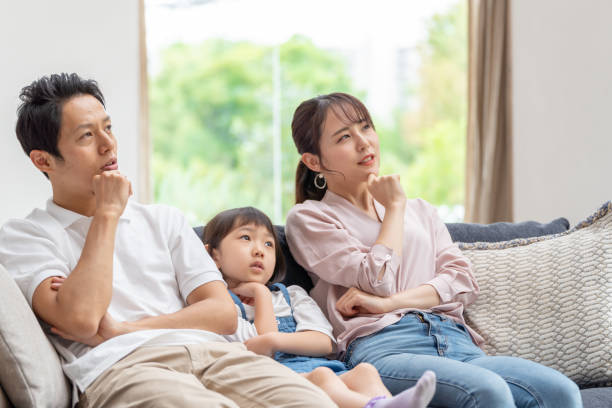 istock young japanese family thinking on the sofa 1304614958