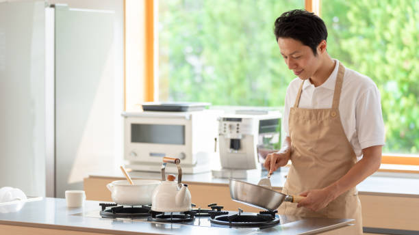 istock young japanese man cooking in kitchen 1304615002