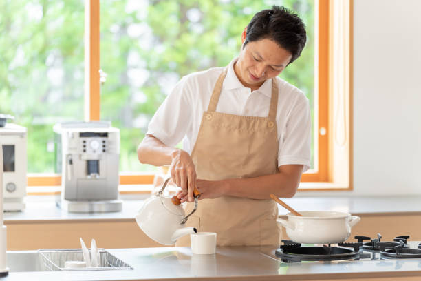 istock young japanese man cooking in kitchen 1304615003