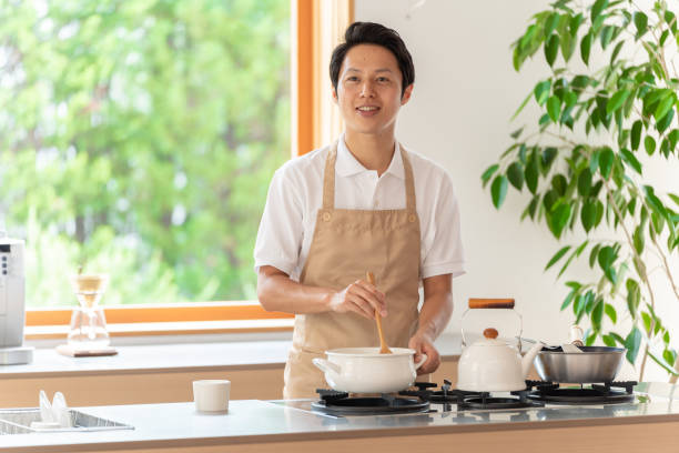 istock young japanese man cooking in kitchen 1304615013