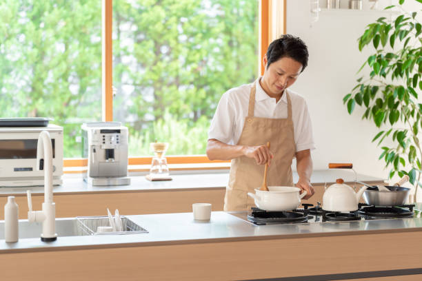 istock young japanese man cooking in kitchen 1304615014