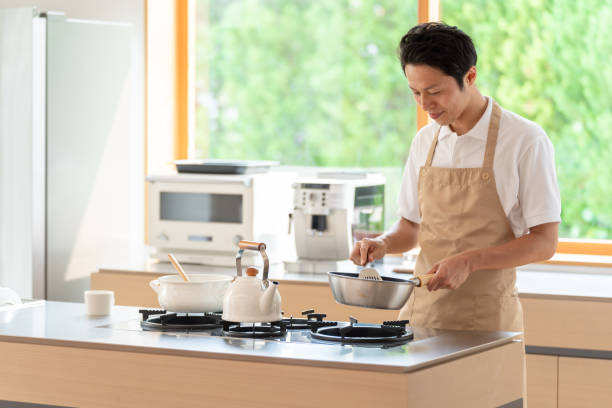 istock young japanese man cooking in kitchen 1304615021