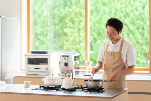 istock young japanese man cooking in kitchen 1304615024