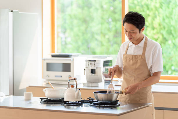 istock young japanese man cooking in kitchen 1304615028
