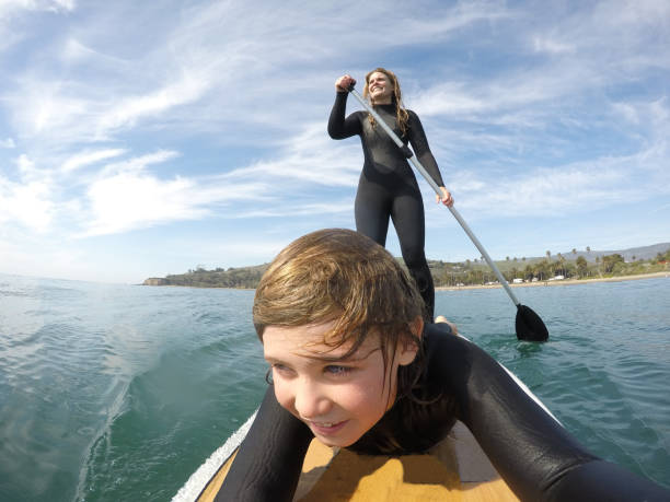 istock Mother and son paddle board happily together. 1304619143