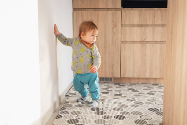 istock One cute baby boy making his first steps at home 1304619159