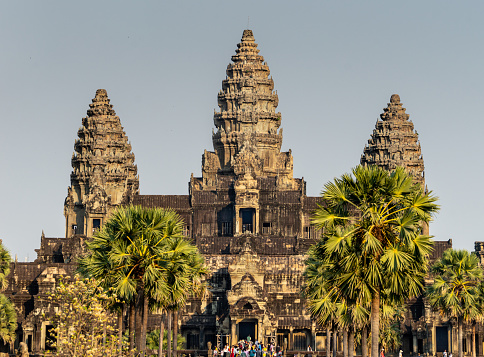 Angkor Wat, Cambodia - January 20, 2020: Lotus bud shaped towers of Angkor Wat are lit by the setting Sun. The Angkor Wat is a Hindu temple complex in Cambodia and is the largest religious monument in the world.