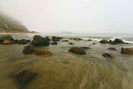 Rocky seashore at overcast foggy day, Morro Bay, California