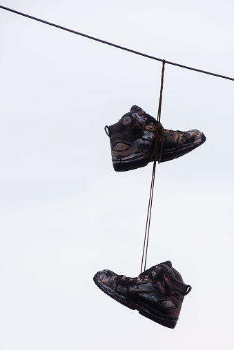 A pair of weathered old boots hang by the laces from a power line along a rural Missouri road on Feb. 28, 2021.