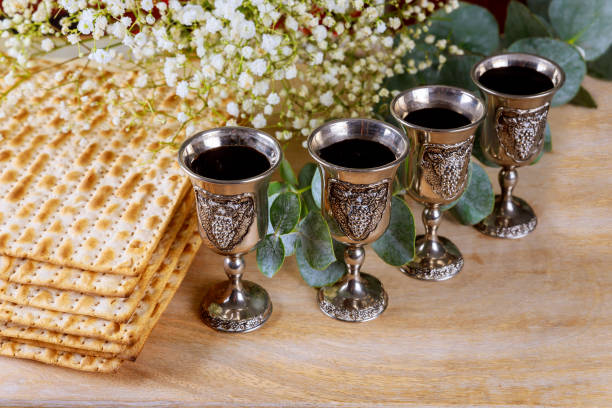 vinho com kosher quatro taças um de matzah a páscoa haggadah em um fundo de madeira - kosher wine - fotografias e filmes do acervo