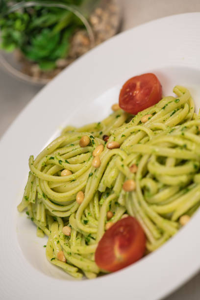 istock green spinach spaghetti with cheese and tomato on wooden table 1304644024
