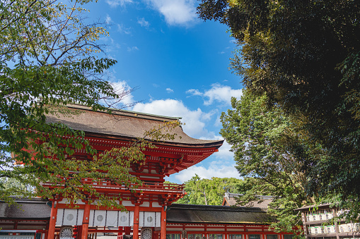 Kyoto, Japan - May 2014: View of the inner courtyard of Heian Shrine with crowd of people walking with main prayer hall, Byakko-rou tower and cloudy sky background.