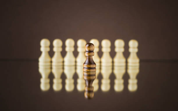 istock Wooden pawns on a dark background. Chess. 1304651050