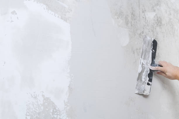 istock A male worker spreads the putty mixture and flattens wall. 1304651447