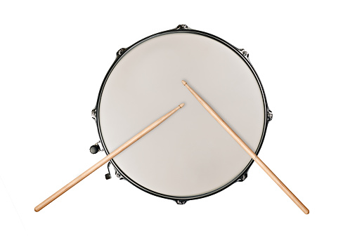 top view of a snaredrum and two drumsticks on white background