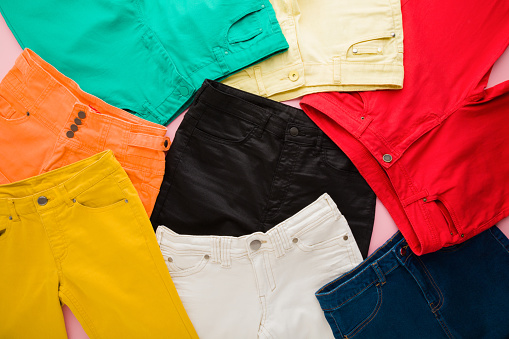 Colorful female jeans background. Closeup. Top down view. Trousers pattern.