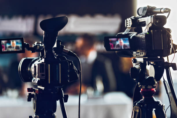 istock Professional Digital Camera Recording Presentation A A Blurred Speaker Wearing Suit 1304663784