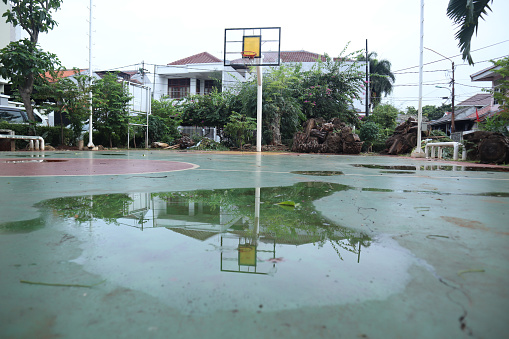 view of basketball poles reflected by the water in the middle of the court