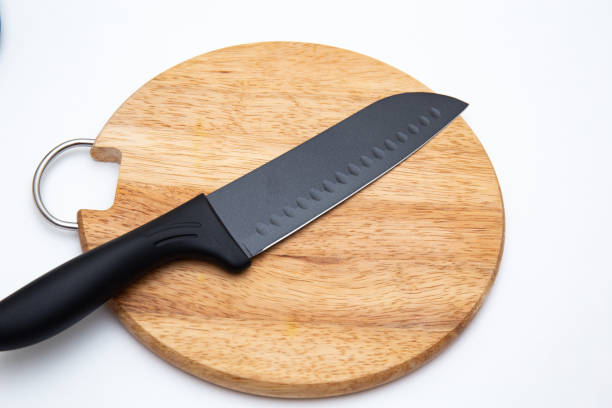 istock Luxury black kitchen knife on chopping board isolated on white 1304667881