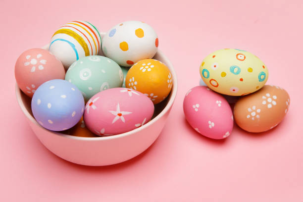 istock Colorful handmade Easter eggs in bowl and on pink background 1304669927