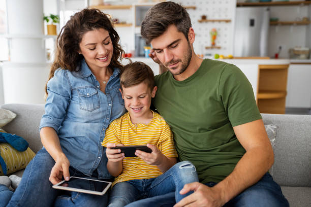 istock Happy family using technology devices together at home. 1304672332