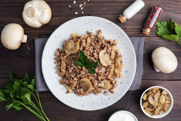 Photo of Boiled buckwheat with stewed mushrooms. Russian traditional food. Healthy diet food. copy space, top view.