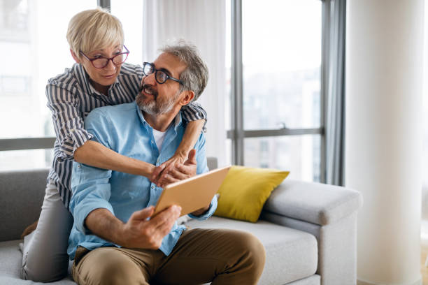 istock Beautiful happy mature couple is using a digital tablet, talking and smiling at home 1304673102