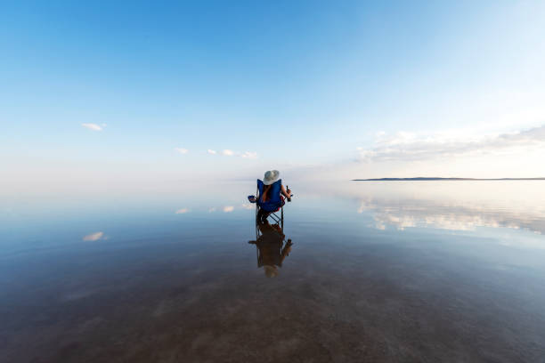 jeune femme s’asseyant sur le transat et regardant à l’horizon au-dessus du lac - water lake reflection tranquil scene photos et images de collection