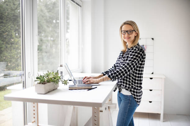 istock Businesswoman working at ergonomic standing workstation. 1304674681