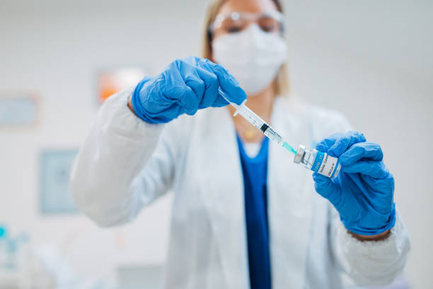 istock Female general practitioner pulling a dose of COVID-19 vaccine with syringe, preparing everything for application 1304676112