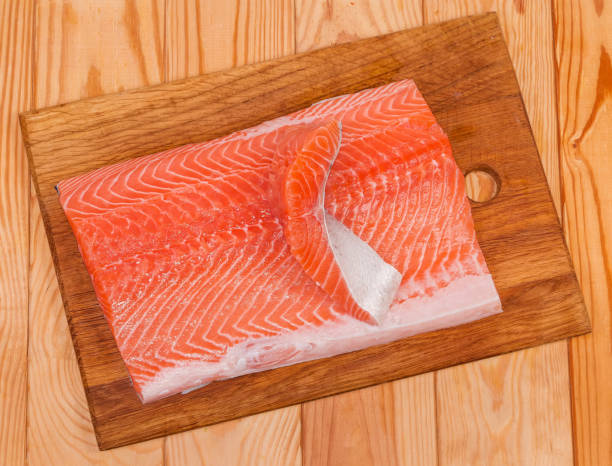 top-ansicht von stücken von lachsfilet auf schneidebrett - vitamin d salmon fillet raw stock-fotos und bilder