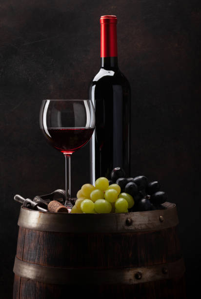 istock Wine bottle, glass and old wooden barrel 1304677205
