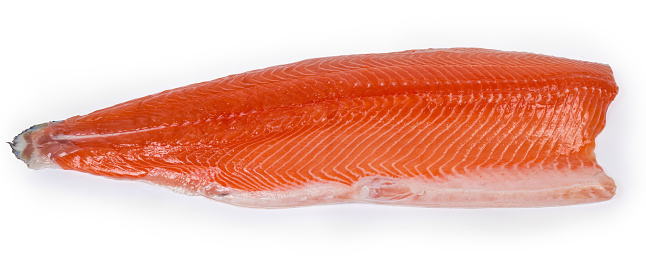 Chilled salmon fillet on the skin as a boneless half of the fish, lies skin side down on a white background