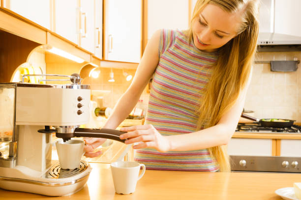 istock Woman in kitchen making coffee from machine 1304677436
